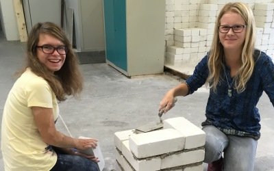Das Bild zeigt zwei Schülerinnen bei der Anfertigung einer Mauer
